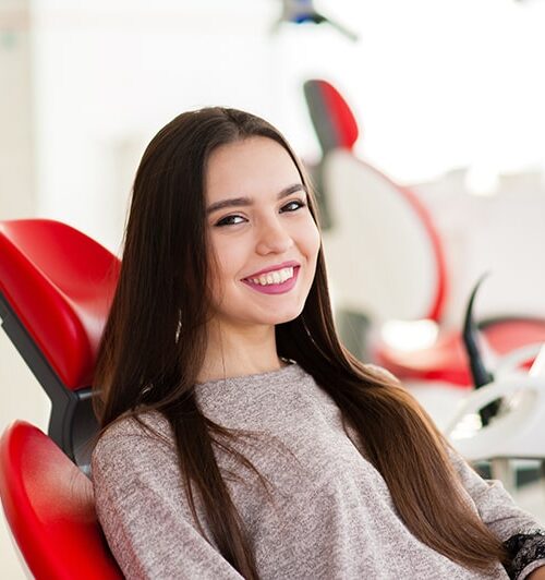 Woman sitting in dentist chair smiling
