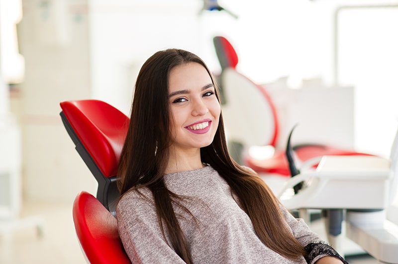 Woman sitting in dentist chair smiling